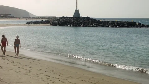On the Beach. Two Women Walking, Two Men Running Stock Footage