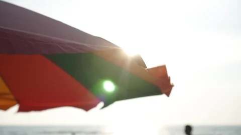 Beach umbrella and sun rays. Beach, summer, parasol against the sky Stock Footage 126643213