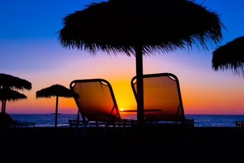 Beach umbrella on the beach at sunset Stock Photos