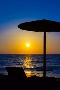 Beach umbrella on the beach at sunset Stock Photos