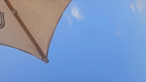 Beach umbrella canopy view of clear sunny blue sky. Summer vacation resort Vidéo 336204467