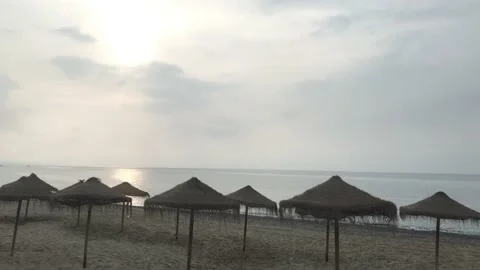 Beach umbrella made of straw on the sandy beach by mediterranean sea Stock Footage 132780443