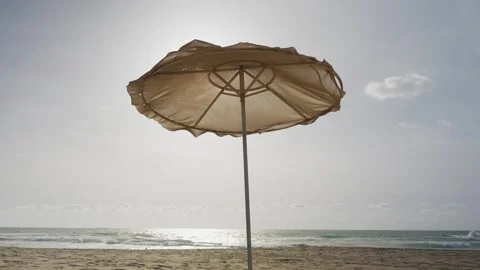Beach umbrella stands alone on soft sand Stock Footage 337033908
