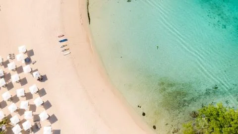 Beach umbrellas and deck chairs on the white beach. Stock Photos