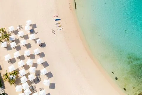 Beach umbrellas and deck chairs on the white beach. Stock Photos