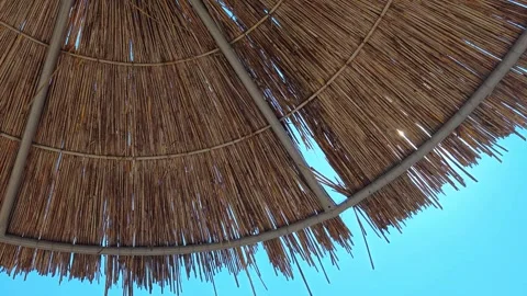Beach umbrellas on a background of blue sky. Close up. Video stock 313475924