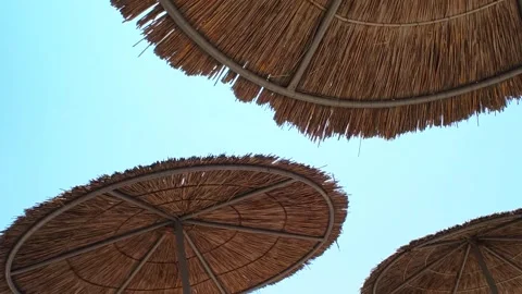 Beach umbrellas on a background of blue sky.  Travel and tourism concept. Stock Footage 314076846