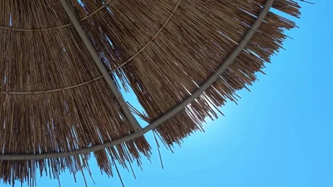 Beach umbrellas on a background of blue sky. Travel and tourism concept. Stock Footage 320056262
