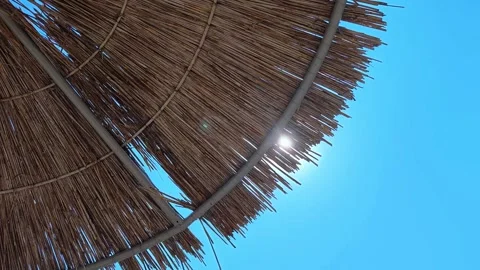 Beach umbrellas on a background of blue sky. Travel and tourism concept. Stock Footage 321142177