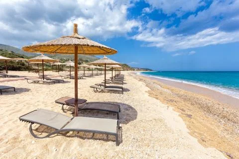 Beach umbrellas in rows on sandy beach with sea Stock Photos