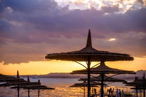 Beach umbrellas on sunset background 스톡 사진