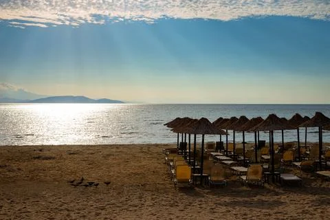 Beach with umbrellas at sunset Stock Photos
