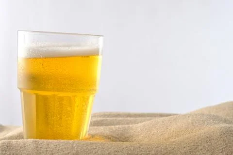 Beach vacation concept. Cool drinks on the beach sand. Cold foamy beer. Close Stock Photos