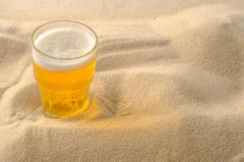 Beach vacation concept. Cool drinks on the beach sand. Cold foamy beer. Close Stock Photos