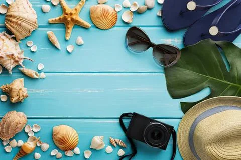 Beach vacation flat lay with shells sunglasses hat camera Stock Photos
