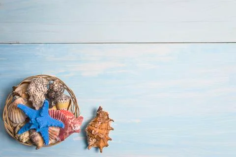 Beach vacations background. Basket with various seashells and starfish on blu Stock Photos