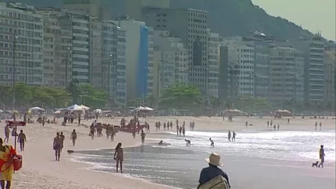 Beach vendors and bikini walking a beach in Rio Stock Footage 80168357