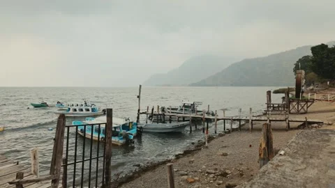Beach view on lake Atitlan with smoke in the air and mountains Video stock 294286965