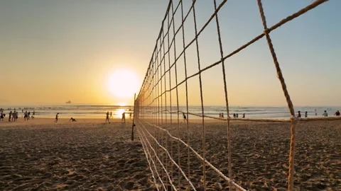 Beach Volleyball Net Swaying in the wind at Sunset with silhouettes of people Vídeos de archivo 342581844