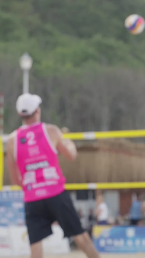 A beach volleyball player getting ready to serve, focusing on the game. The Stock Footage 280139827
