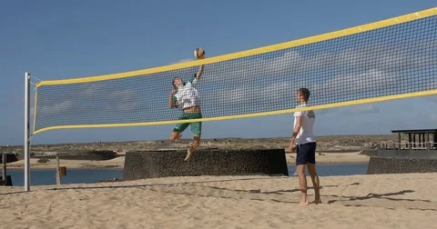 A Beach volleyball player sets up his team mate to spike the shot. Vídeos de archivo 79822942