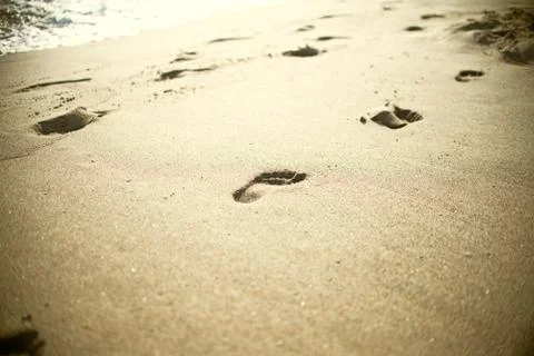 Beach, wave and footsteps Stock Photos