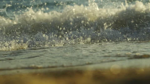 Beach wave splashing at sunset Stockbeeldmateriaal 212888870