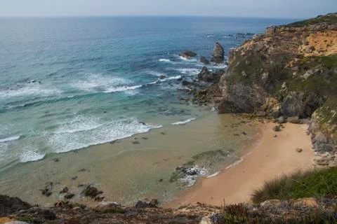Beach with waves and cliffs Stock Photos
