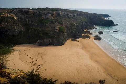Beach with waves and cliffs Stock Photos