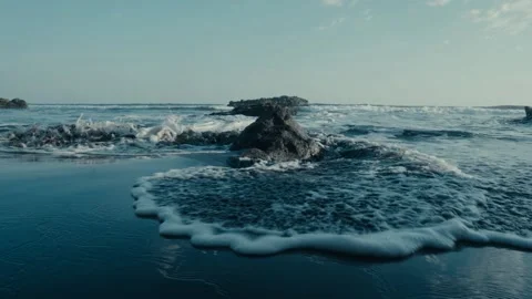 Beach waves and rocks, black sand, slow motion Stock Footage 134438099