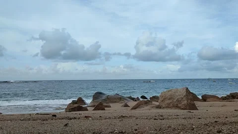 Beach with waves crashing, pebbles, big rocks and boats Stock Footage 276363540