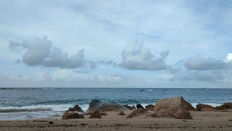 Beach with waves crashing, pebbles, big rocks and boats Stock Footage 276363717