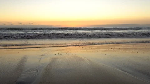 Beach waves crashing the sand on an idyllic sunset at Pacific Ocean waters 스톡 동영상 113848862