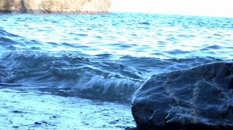 Beach waves hitting rock Видео 45531597