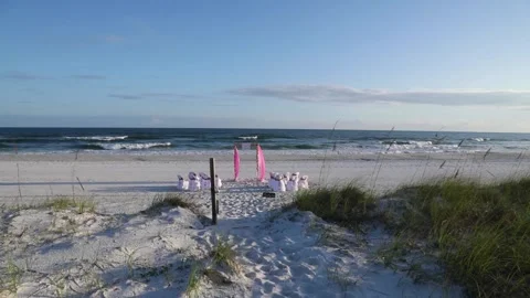 Beach wedding decorations arch and chairs in front of ocean Stock Footage 139854956