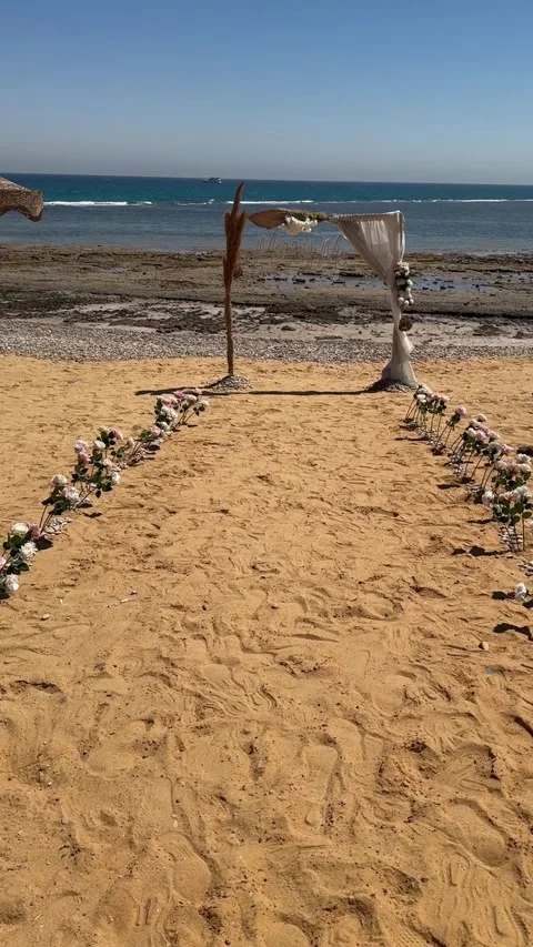 Beach wedding setup with a rustic floral arch overlooking the sea, close up hot Video stock 345068761