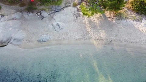 Beach with white sand clear blue tranquil sea and walking path. bird aerial view Stock Footage 138950422