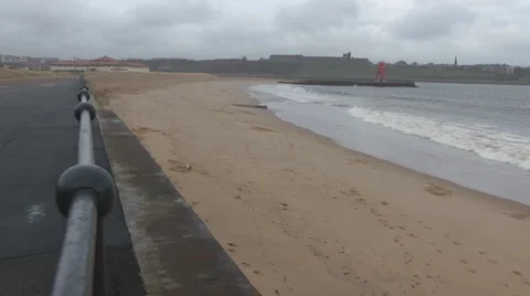 Beach in winter with breaking waves. Small white dog near end of clip. Stock-Footage 1091348