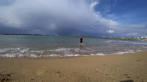 By the beach in winter with a man coming out of the water Stock Footage 182277110