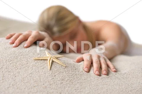 Beach - woman with starfish lying in sand Stock Photos