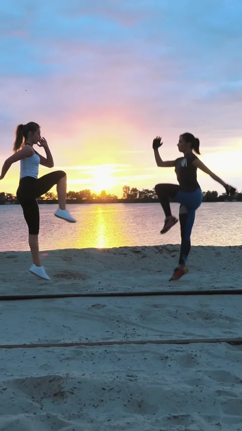 Beach workout during sunset with dynamic exercising duo Stock Footage 303733615