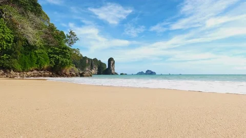 Beach with yellow sand next to the mountain with green trees Stock Footage 134069647