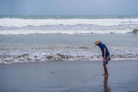 Beachcomber Gathering Items from the Shoreline Foto stock