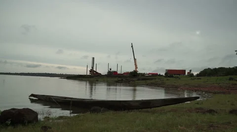 A beached boat on shore and an extraction platform in the background. in Africa Stock Footage 67407706