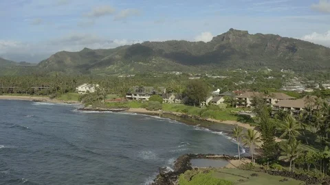 Beachfront condominiums below a mountain ridge on Kauai Vídeos de archivo 96047225