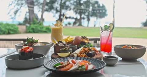 Beachfront Dining Table with Gourmet Food and Cocktails Stock Footage 345695320