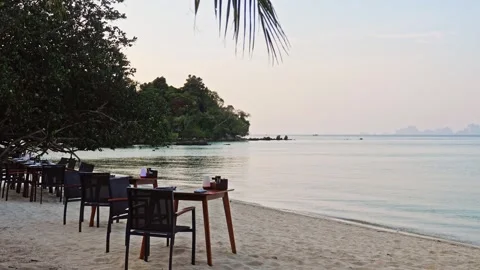 Beachfront dining tables overlooking calm ocean water Видео 336299922