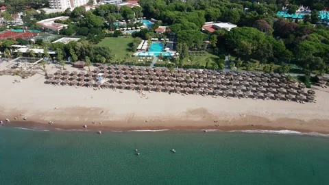 Beachfront Resort with Straw Umbrellas and Sun Loungers Stock Footage 296514225
