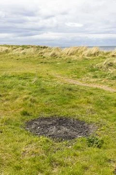 Beachfront Sand Dune with Extinguished Campfire Stock Photos