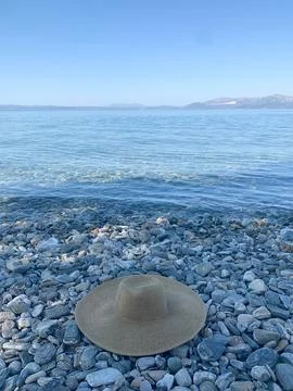 Beachfront scene with a straw hat Stock Photos